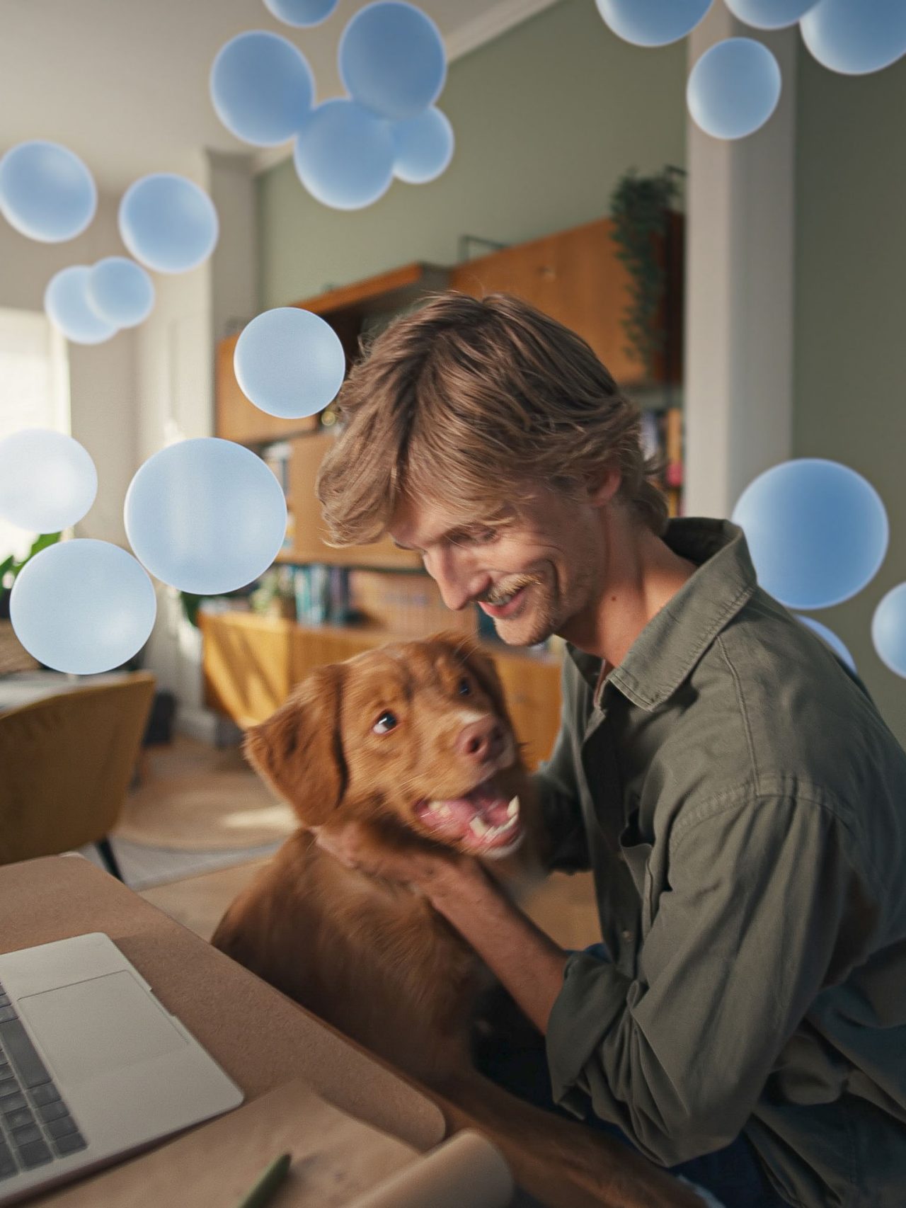 Nuori mies pöytänsä ääressä koiransa kanssa nauttii hiljaisesta mukavuudesta ja älykkäästä ilmastoinnista